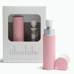Light pink travel size lubricant 15ml glass vial and aluminum travel case with packaging labeled 'uberlube' on a white background — 23